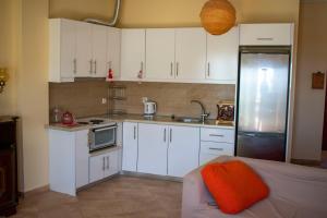 a small kitchen with white cabinets and a refrigerator at FILIS APARTMENT in Agios Andreas