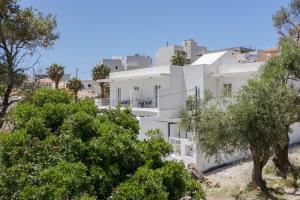a white apartment building with trees in the foreground at Secret Nest in Plakias