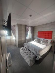 Schlafzimmer mit einem großen Bett mit einem roten Kopfteil in der Unterkunft Kings Boutique Hotel in Blackpool