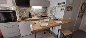 a kitchen with a wooden counter top with two plates on it at Studio avec balcon face à la montagne in Cauterets
