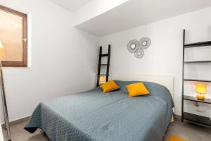 una camera con un letto con due cuscini gialli di Apartments Vilma a Opatija