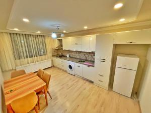 a kitchen with a table and a refrigerator in it at Şahin Home in Uzungöl
