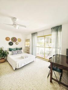 a bedroom with a bed and a desk and a window at ESTUDIO BLEGAMAR TERRAZA - Playa, WiFi y Aparcamiento in El Puerto de Santa María +26 photos