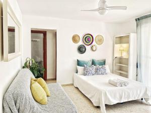 a white bedroom with a bed and a ceiling fan at ESTUDIO BLEGAMAR TERRAZA - Playa, WiFi y Aparcamiento in El Puerto de Santa María