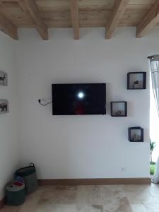 a living room with a tv on a white wall at Gite de la Diligence in Le Fied