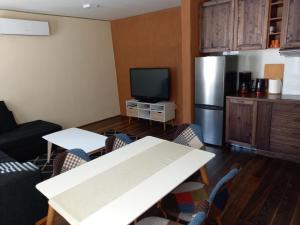 a living room with a table and a refrigerator at Yellow Center Holiday Home in Pärnu