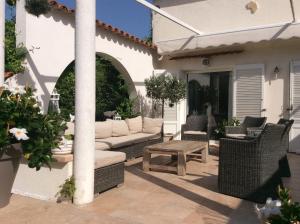 a patio with a couch and a table and chairs at Le cabanon in Antibes