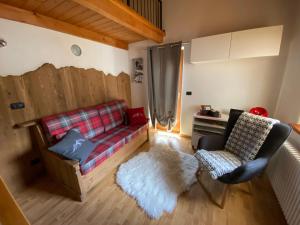 ein Wohnzimmer mit einem Sofa und einem Stuhl in der Unterkunft La Guida e l'Architetto in Saint-Rhémy-en-Bosses