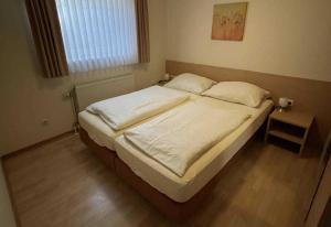 a bedroom with a large bed with white sheets and pillows at Haus Kiek Ut Apartment 22 in Timmendorfer Strand