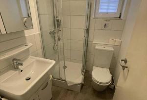 a bathroom with a shower and a toilet and a sink at Haus Kiek Ut Apartment 22 in Timmendorfer Strand