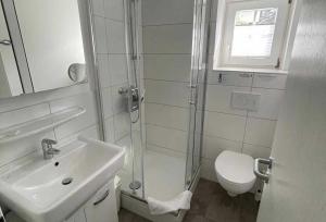 ein Bad mit einer Dusche, einem Waschbecken und einem WC in der Unterkunft Haus Kiek Ut Apartment 24 in Timmendorfer Strand