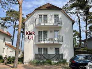 Ein weißes Gebäude mit den Worten, die auf ihm stehen. in der Unterkunft Haus Kiek Ut Apartment 24 in Timmendorfer Strand