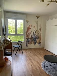 una sala de estar con una pintura en la pared en Studio quartier prisé de la Genette, en La Rochelle