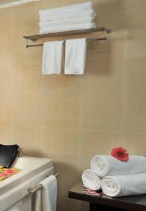 a bathroom with towels on a shelf next to a sink at Best Western Maryland in Chandīgarh
