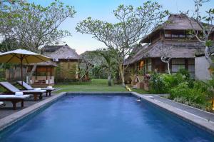 a villa with a swimming pool in front of a house at Chili Ubud Cottage in Ubud
