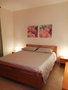 - une chambre avec un lit orné de deux peintures murales dans l'établissement Matera Da - Mare, à Marina di Pisticci