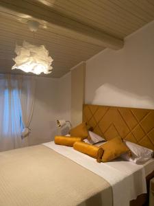 a bedroom with a bed with yellow pillows on it at Casa Tosić in Rovinj