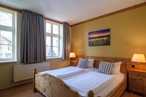 a bedroom with a large bed with two windows at Hotel Zum Harzer in Clausthal-Zellerfeld