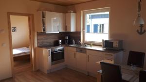 a small kitchen with a sink and a microwave at Ferienhaus Seestern in Altefähr