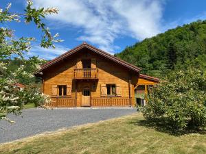 a log house with a balcony on the front of it at Gîte Chalet avec bain nordique et piscine 11 pers Hautes Vosges in Plainfaing
