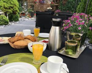 einen Tisch mit Essen und einen Krug Orangensaft in der Unterkunft Gästehaus Schmidt in Bad Lippspringe