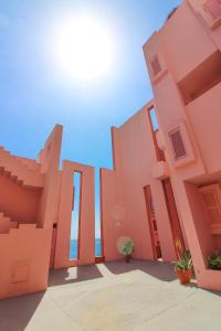um edifício rosa com o oceano ao fundo em Apartment in Muralla Roja - 0406 em Calpe