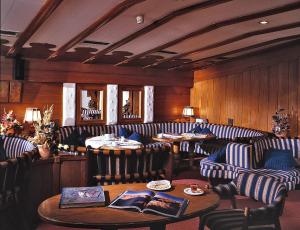 un ristorante con divani, tavoli e sedie di Hotel Miramonti Corvara a Corvara in Badia