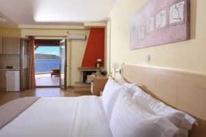 Schlafzimmer mit einem Bett und Meerblick in der Unterkunft Faros Luxury Suites in Marathopoli