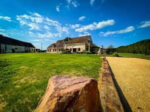 a large tree stump in front of a house at Villa festive HOMAZING piscine privée 1h de Paris in Chantecoq