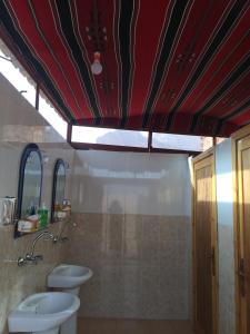 a bathroom with two toilets and a red ceiling at Bedouin Expedition in Wadi Rum