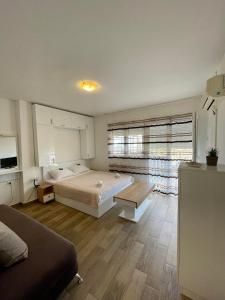 a bedroom with a bed and a large window at 4 Studios Becic in Budva