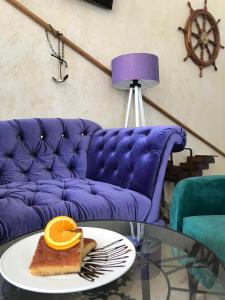 a table with a plate of food on a purple couch at Hotel Palma Jaz Budva in Budva