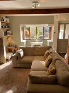 a living room with a couch and a table at Calderside Cottage (2 BDR Central Hebden Bridge) in Hebden Bridge
