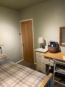 a bedroom with a bed and a desk with a mirror at Calderside Cottage (2 BDR Central Hebden Bridge) in Hebden Bridge