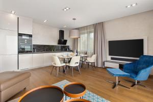 a living room with a table and chairs and a television at Luxury Apartment Iris Adriatica ***** in Opatija