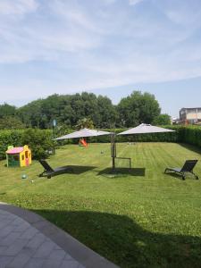 a park with playground equipment and umbrellas on the grass at Il giardino di Pietro in Monza