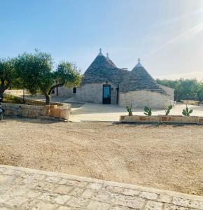budynek z dwoma dachami krytym strzechą na polu w obiekcie I Trulli del Vagabondo - Complex of Trulli with Private Pool w Alberobello