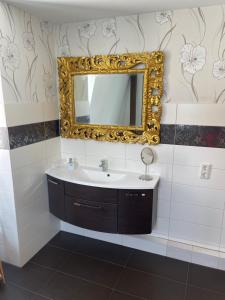 a bathroom with a sink and a mirror on the wall at Ferienwohnung Baars in Bad Sachsa +10 photos