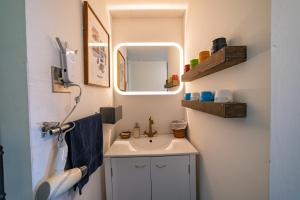a small bathroom with a sink and a mirror at Ichi The Hostel in Minamicho