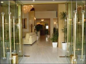 a living room with a white couch and glass cases at Hotel Meletiou in Thiva