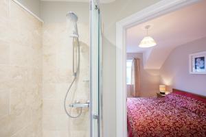 a bathroom with a shower and a bed at Quiet Edwardian era House, Painswick in Painswick