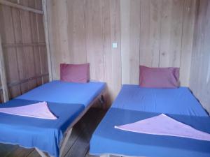 two beds in a room with wooden walls at Happiness Guesthouse in Koh Rong Sanloem