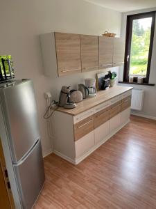 a kitchen with a stainless steel refrigerator and wooden floors at Ferienwohnung Baars in Bad Sachsa