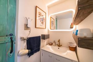 un bagno con lavandino e specchio di Ichi The Hostel a Minamicho