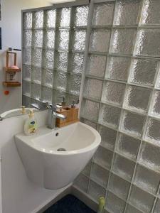 een badkamer met een wastafel en een glazen wand bij Stylish & Luxury 2-bed parkside apart with pool in Phoenix