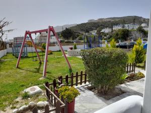 un parque infantil con columpio en un patio en Villa Bel Passo Apartments en Kefalos