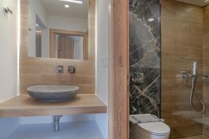 a bathroom with a stone sink and a shower at Secret Nest in Plakias