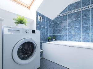 a laundry room with a washing machine and a tub at Appartement Saint-Lary-Soulan, 5 pièces, 8 personnes - FR-1-296-306 in Saint-Lary-Soulan