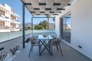 a patio with a table and chairs on a balcony at Secret Nest in Plakias