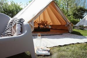 Zelt mit einem Tisch und einer Flasche Wein in der Unterkunft Bell Tent Parc Bûten Jubbega in Jubbega-Schurega